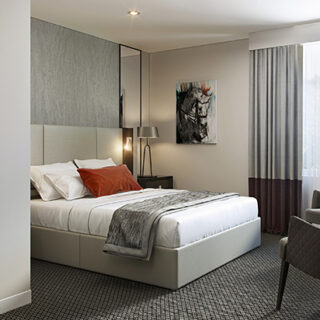a hotel double bedroom with orange cushion