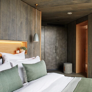 a bedroom with feature timber headboard and green accessories
